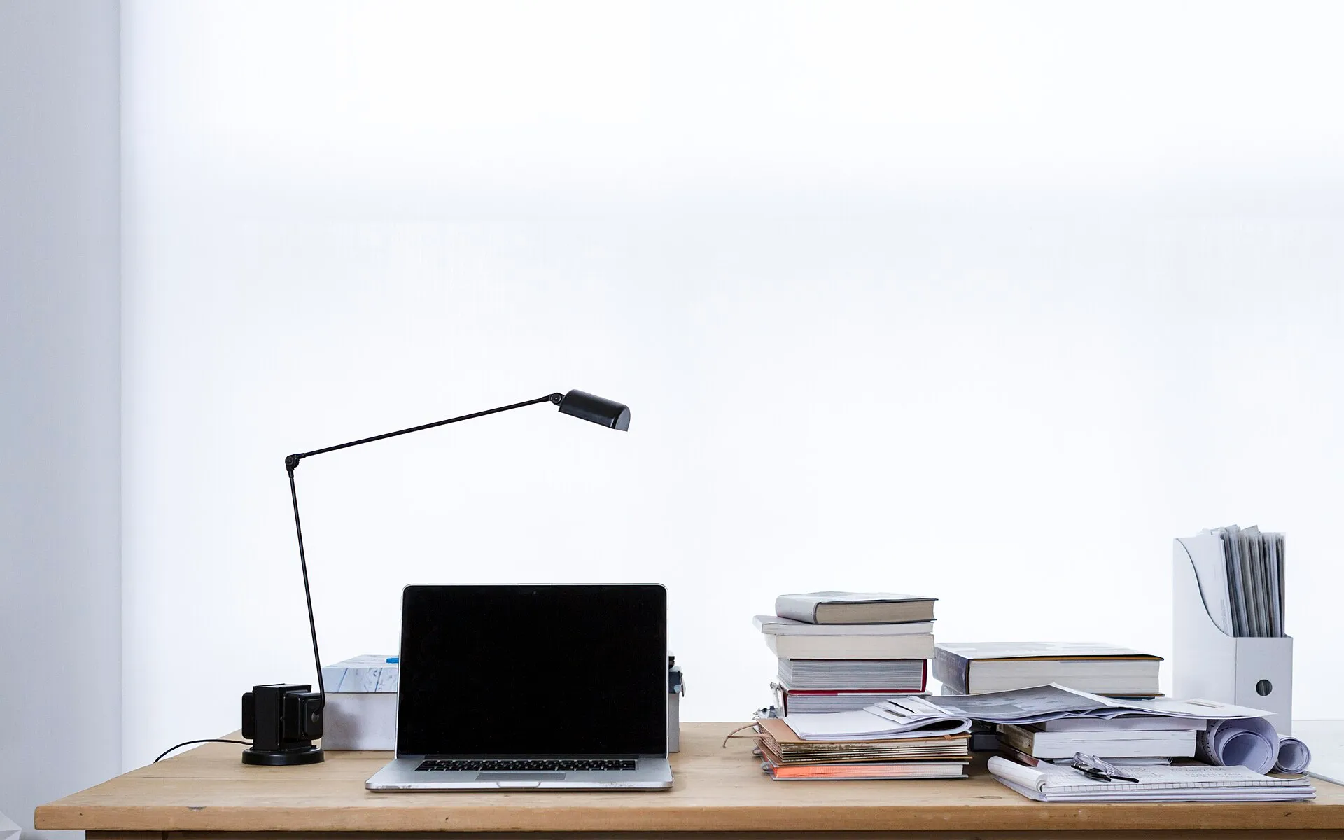 Laptop on desk book stacks