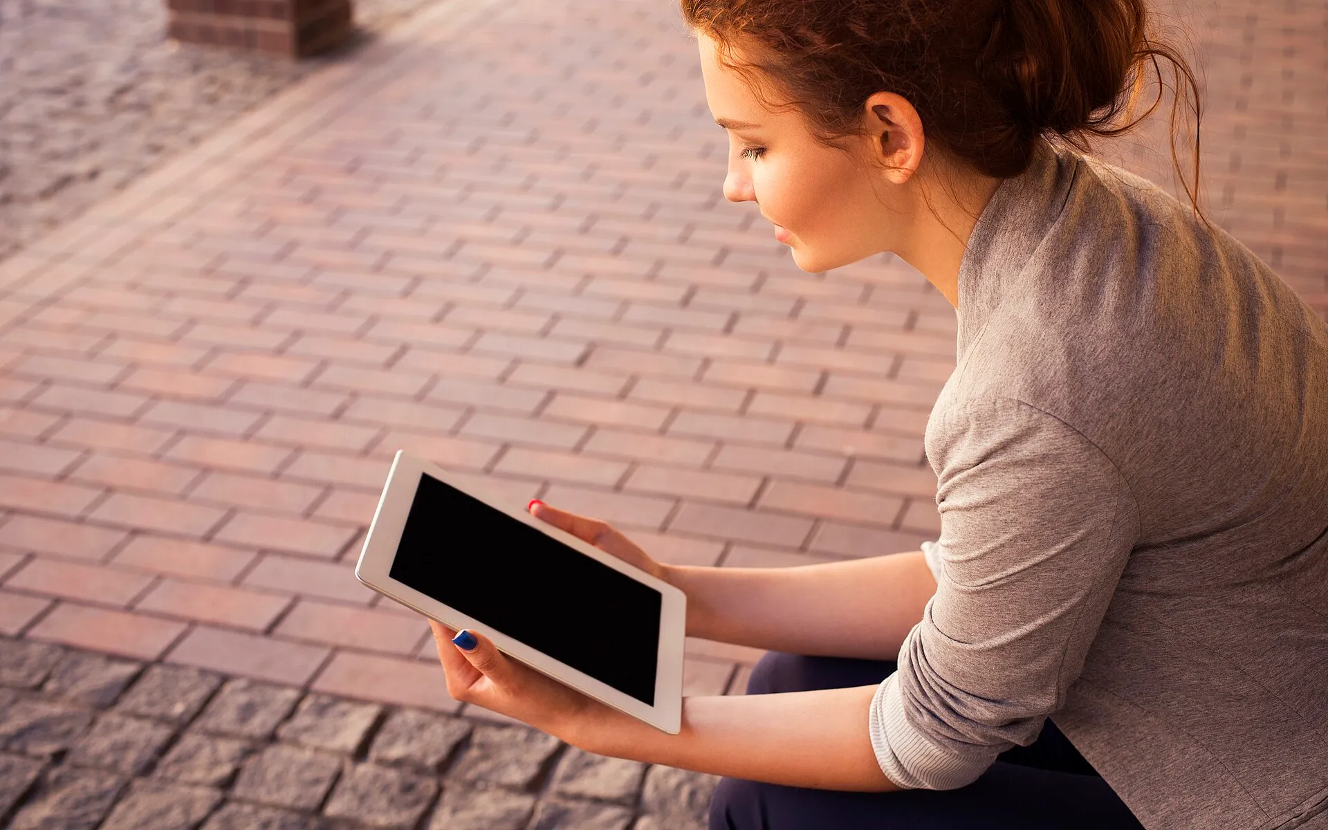 Woman with blue nails reading ipad