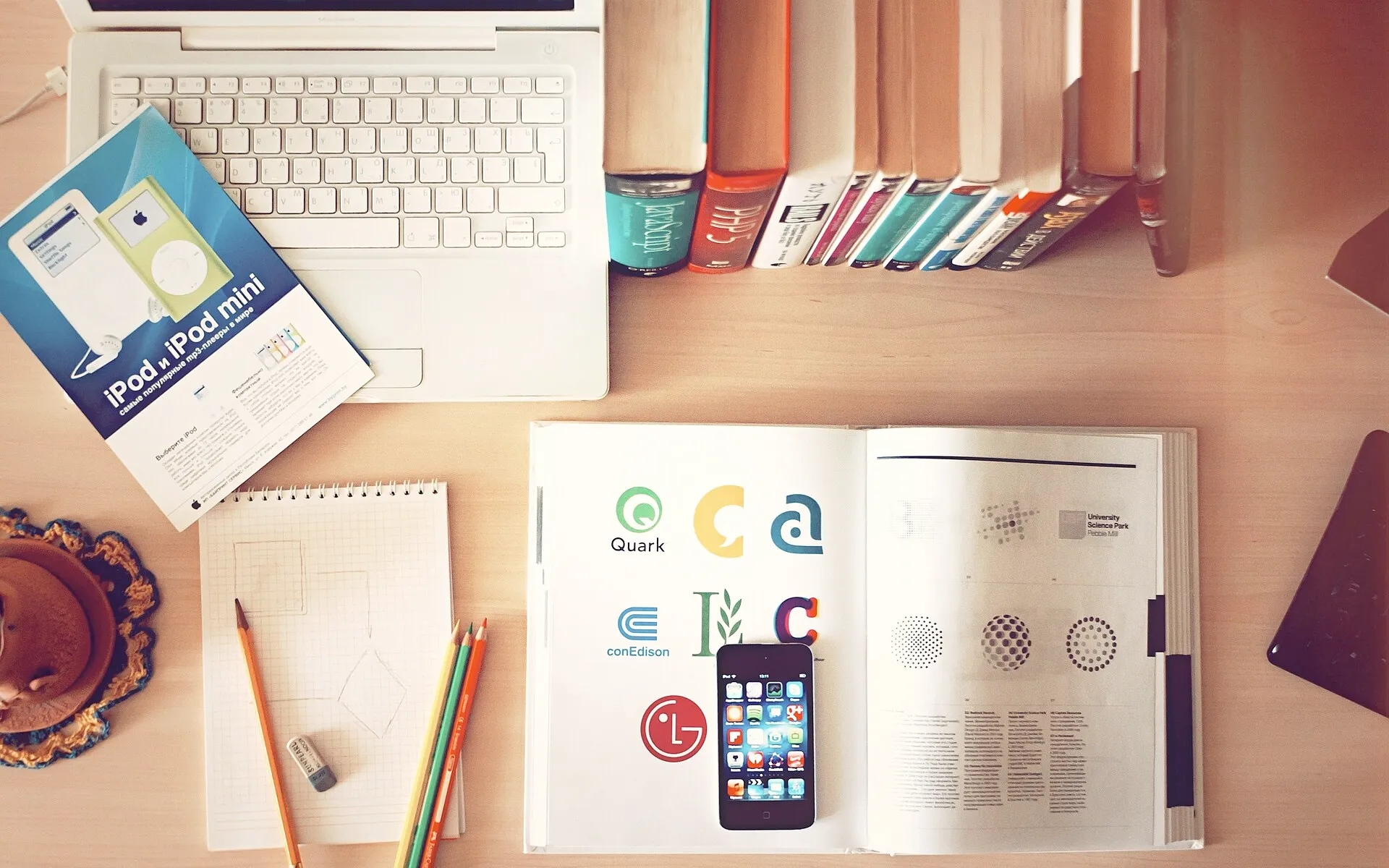Books, pencils, laptop, and iphone on a desk