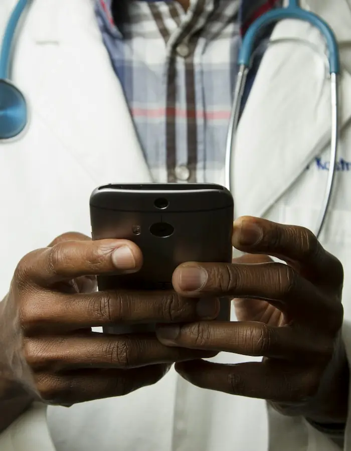 Doctor in a white coat using a smartphone
